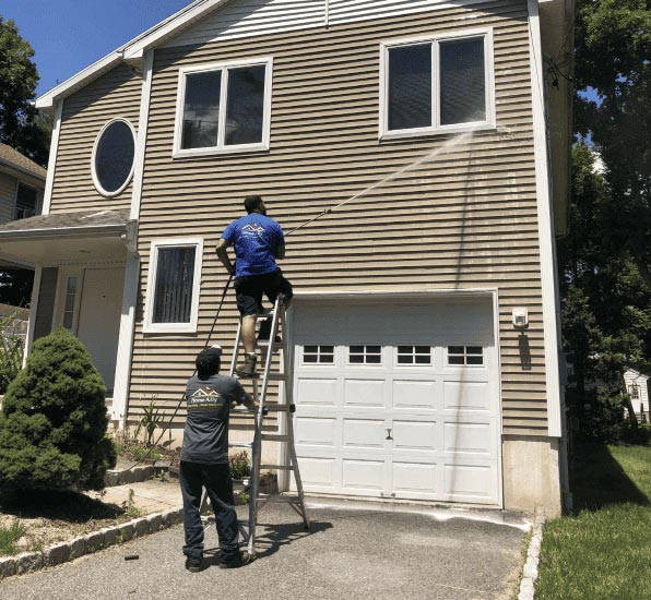 men are helping each other in cleaning the window